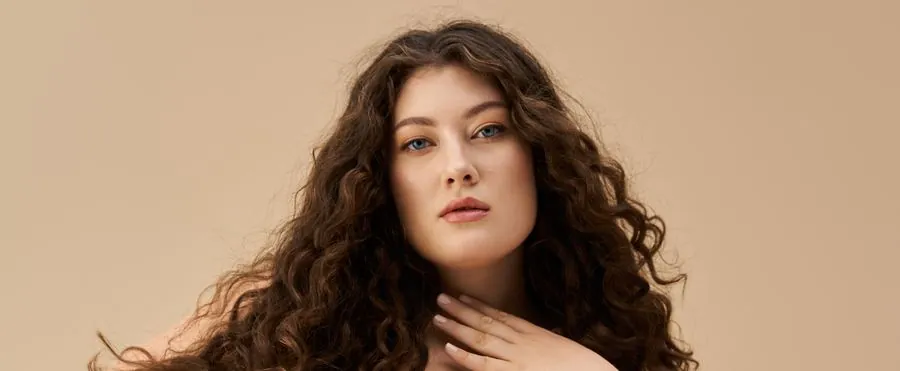 A confident curvy woman with curly hair